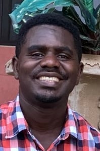 Ugandan man seated outdoors